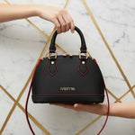 IVORYNN black bag held - front view on gold marble
