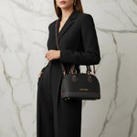 IVORYNN black bag on arm - three-quarter view on gold marble