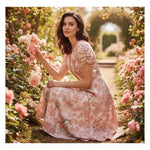 Woman in floral dress kneeling in a rose garden, stylish fashion at Ivorynn