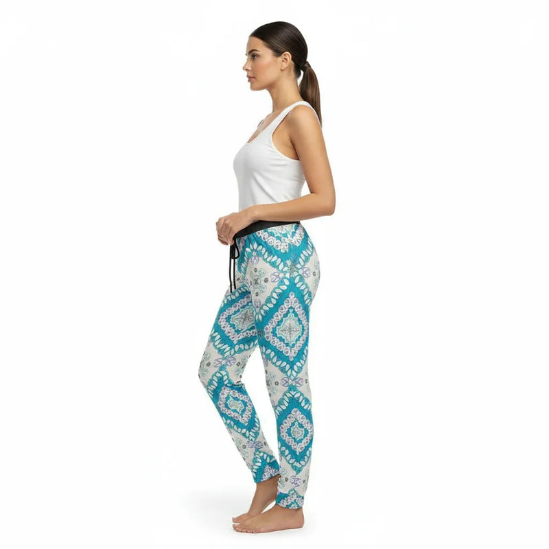 Woman in white tank top and blue geometric print pants, stylish women's fashion at Ivorynn