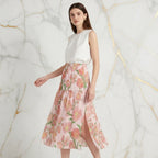 Woman modeling Ivorynn floral midi skirt and white sleeveless top in a luxury fashion setting