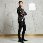 Man in stylish printed jacket and black jeans poses against a marble wall at Ivorynn fashion store