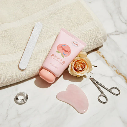 Fruit Fragrance Milky Hand Cream packaging with peach design on marble surface, accompanied by beauty tools and a rose.
