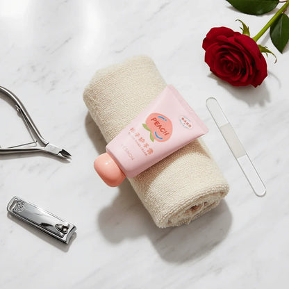 Fruit Fragrance Milky Hand Cream on a soft towel with nail care tools and a rose, showcasing hydration and nourishment.