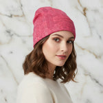 Woman wearing a pink floral knitted hat, angled front view, stylish winter accessory from Ivorynn
