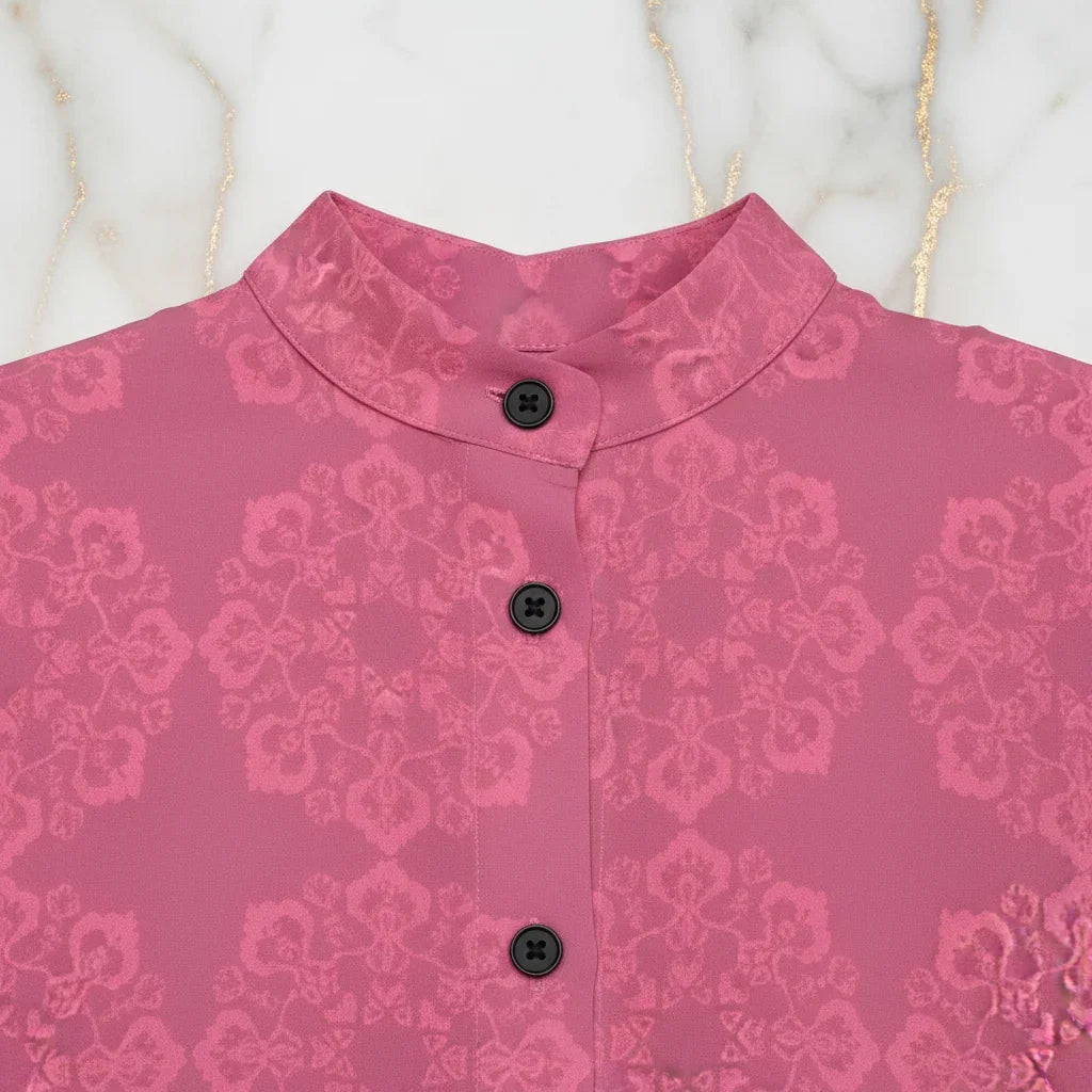 Pink floral jacquard shirt with black buttons and mandarin collar on marble background