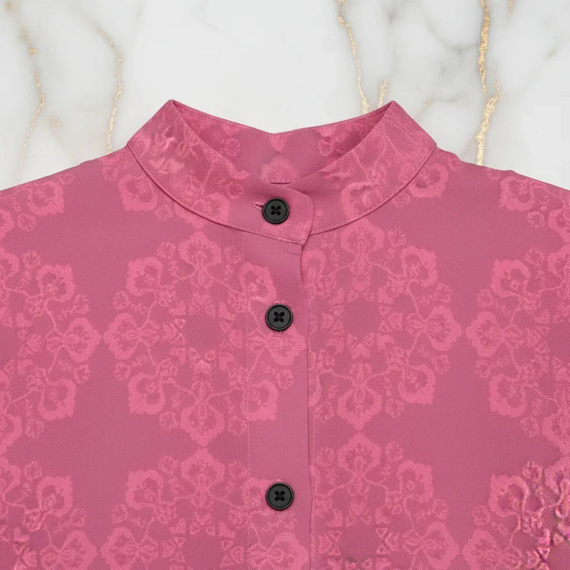 Pink floral jacquard shirt with black buttons and mandarin collar on marble background
