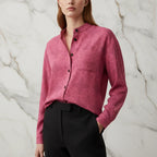 Woman wearing a pink floral button-up shirt from Ivorynn, styled with black pants