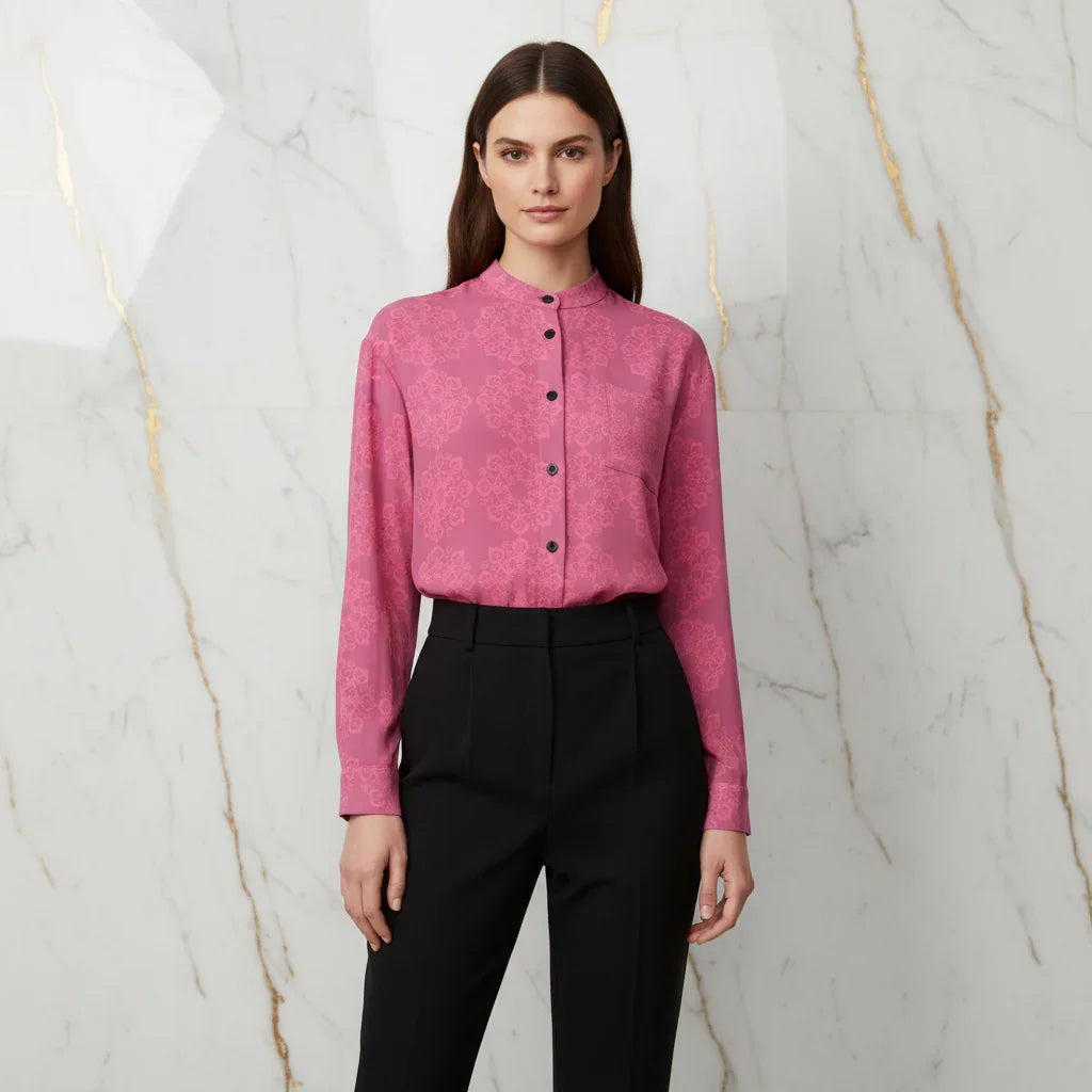 Woman in pink floral shirt and black trousers standing against marble wall, Ivorynn fashion