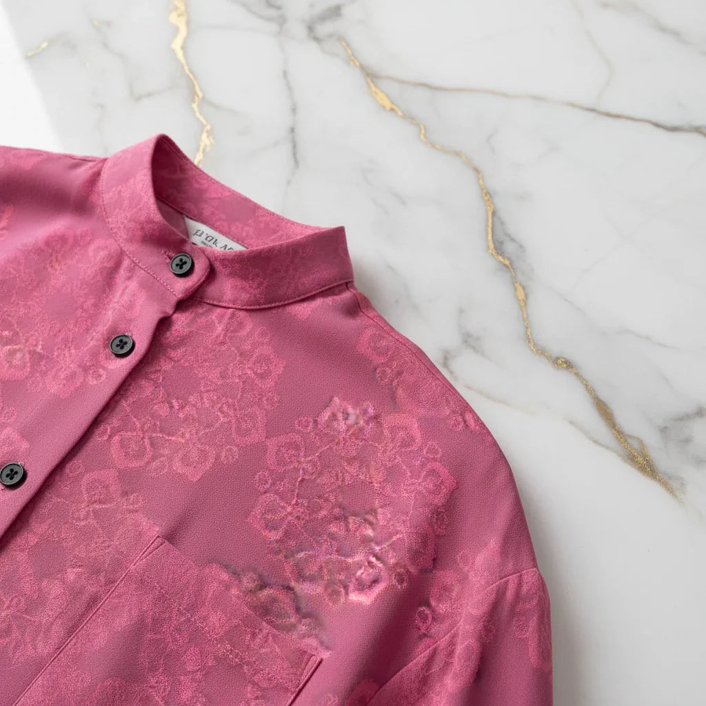 Pink floral shirt with subtle texture and black buttons on marble surface, Ivorynn fashion