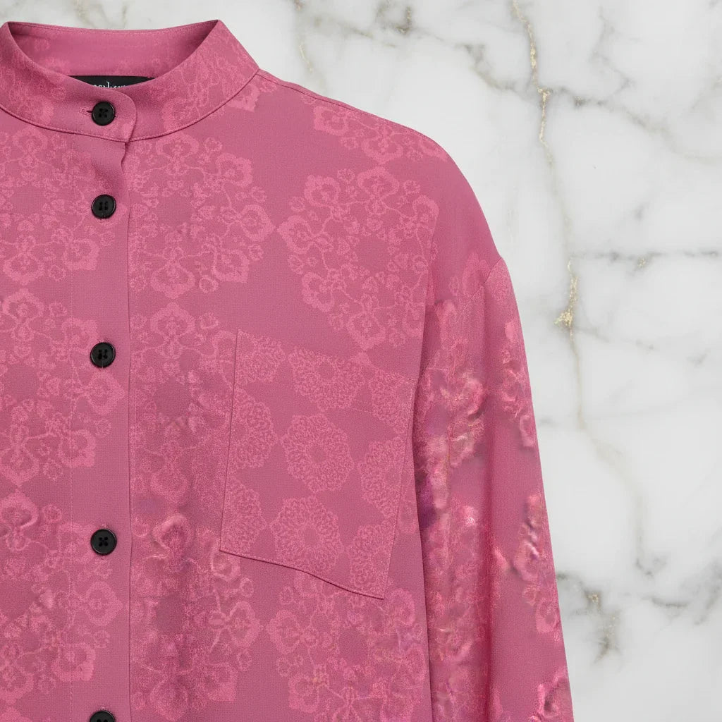 Pink floral shirt with chest pocket and black buttons on marble background at Ivorynn