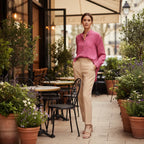 Woman in a pink floral shirt and beige pants, standing on a terrace with potted plants, stylish fashion at Ivorynn