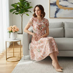 Woman in a floral dress sitting on a modern sofa, showcasing Ivorynn women's fashion.