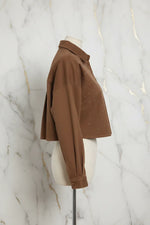 Side profile of brown denim shirt on marble background