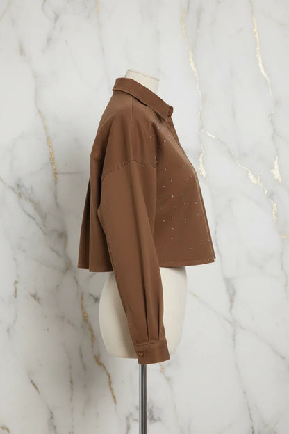 Side profile of brown denim shirt on marble background