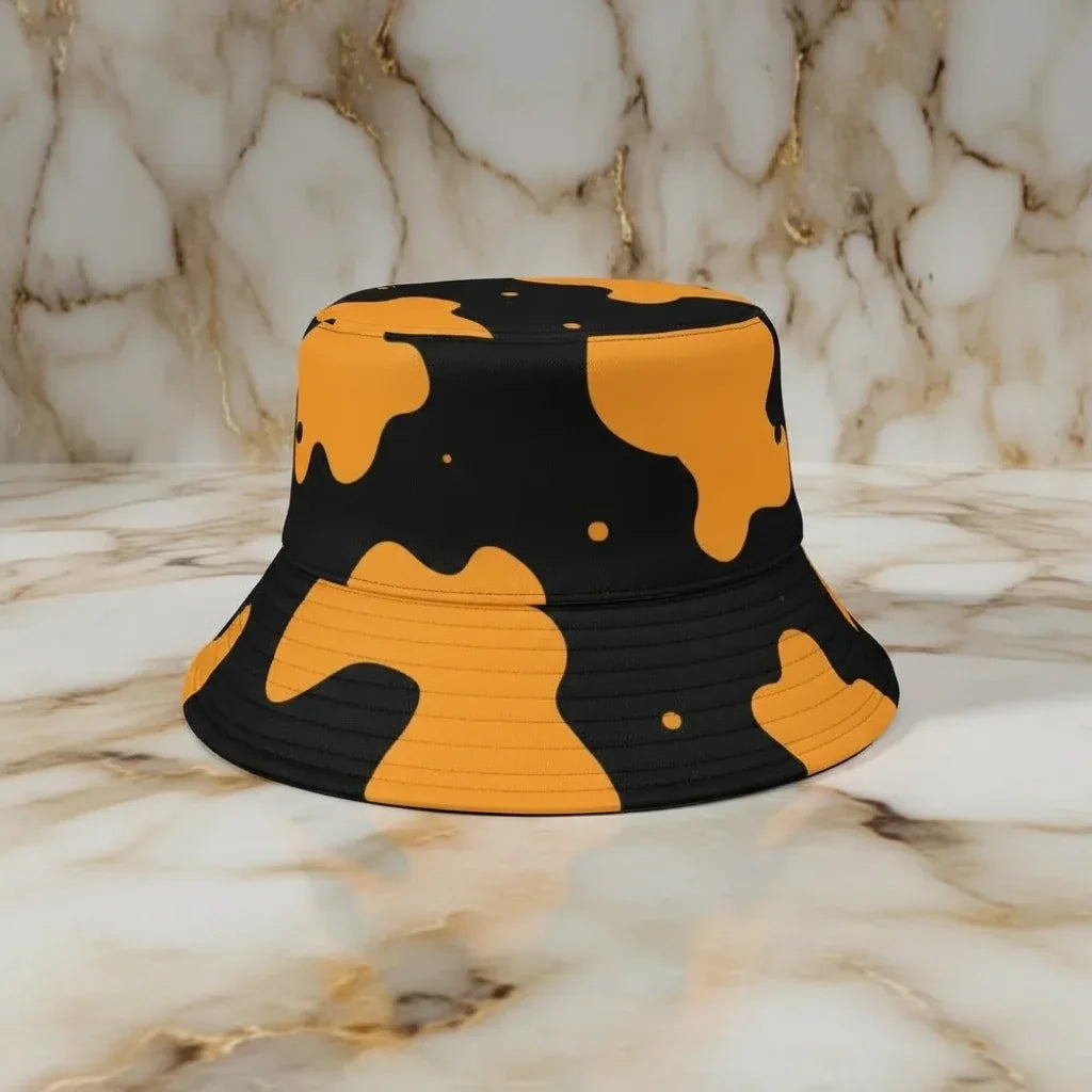 Yellow and black bucket hat with abstract pattern on marble surface at Ivorynn