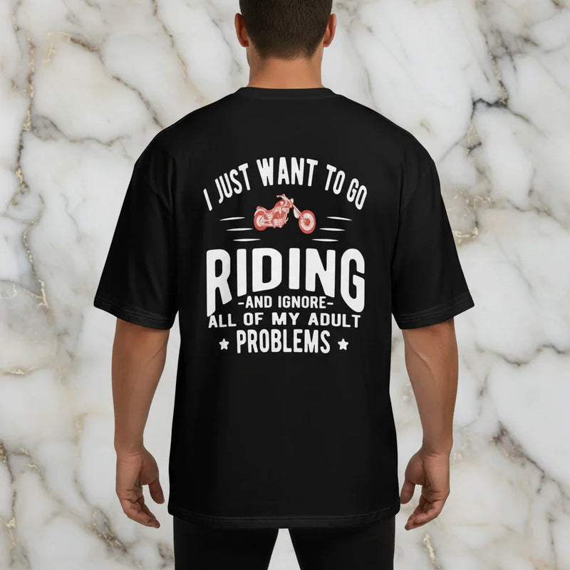 Sporty man in black graphic t-shirt with riding quote, standing against marble background