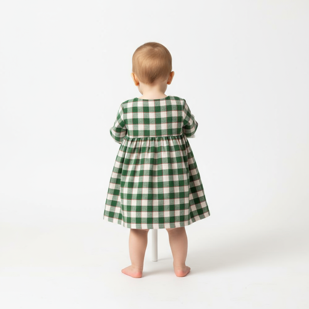 Studio back view of baby in plaid dress