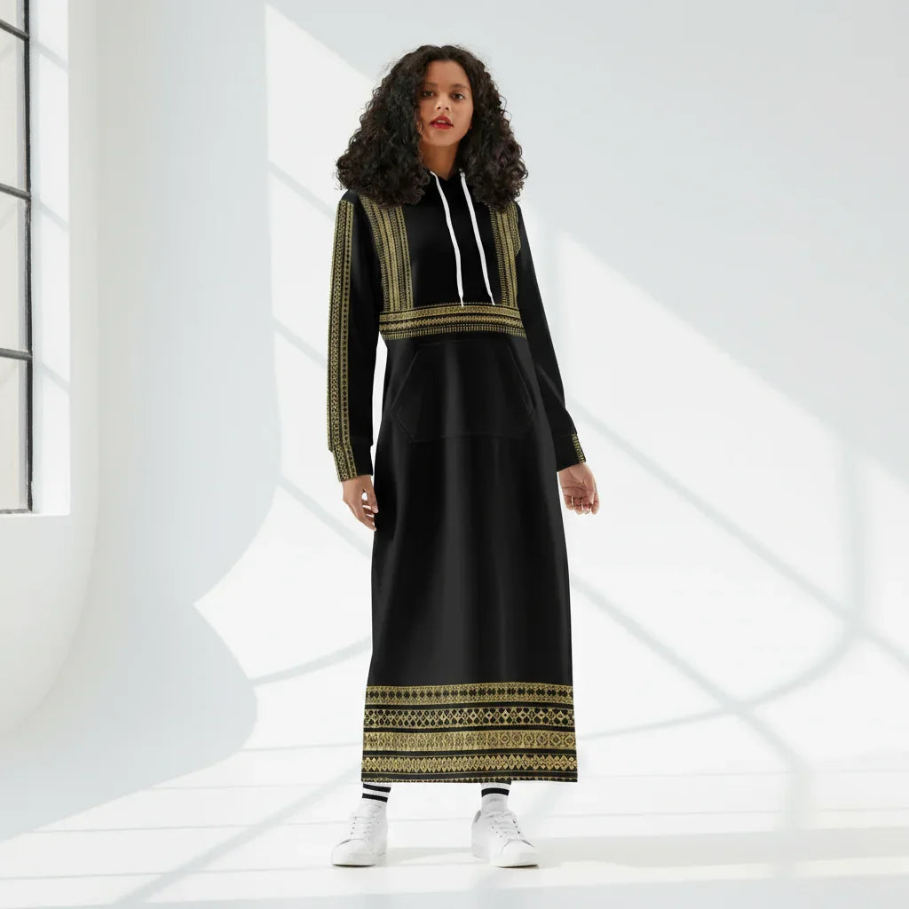 Woman modeling a black and gold long hoodie dress in a sunlit studio for Ivorynn fashion