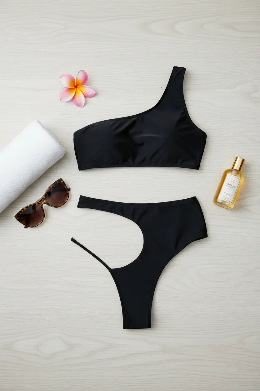 Swimsuit on wooden surface with towel and accessories