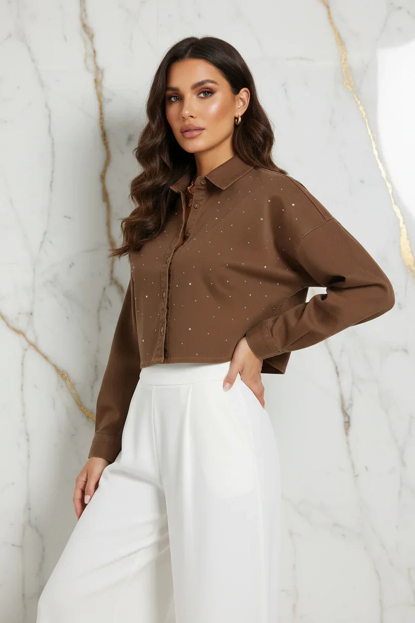 Three-quarter angle of brown denim shirt with white pants on marble background