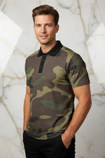 Man in camo print polo shirt with black collar, hands in pockets, standing against marble wall, Ivorynn fashion