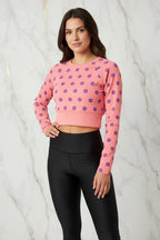 Woman in pink polka dot crop top and black leggings, stylish apparel from Ivorynn
