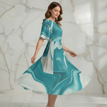 Woman twirling in teal marble print dress, stylish apparel by Ivorynn, marble wall background