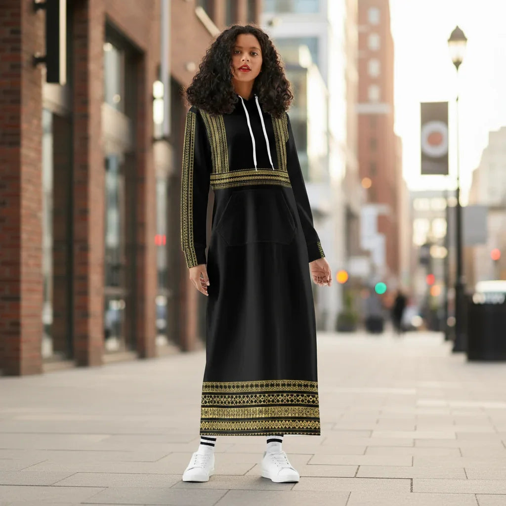Woman in stylish long black and gold hoodie dress with white sneakers in urban outdoor setting