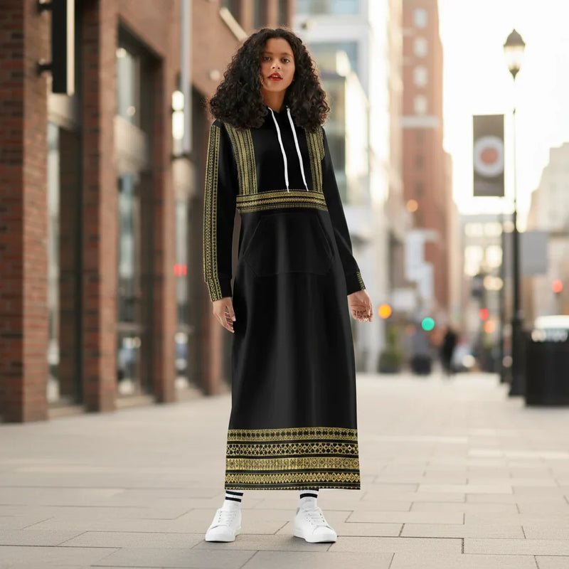 Woman in stylish long black and gold hoodie dress with white sneakers in urban outdoor setting
