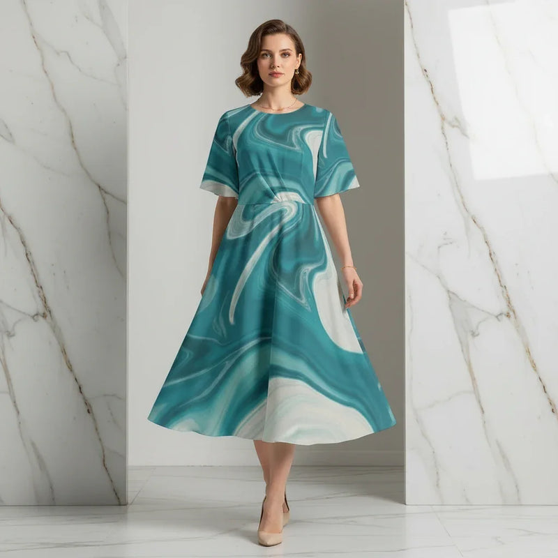 Woman wearing a teal marble print midi dress and nude heels in a modern marble interior, Ivorynn fashion