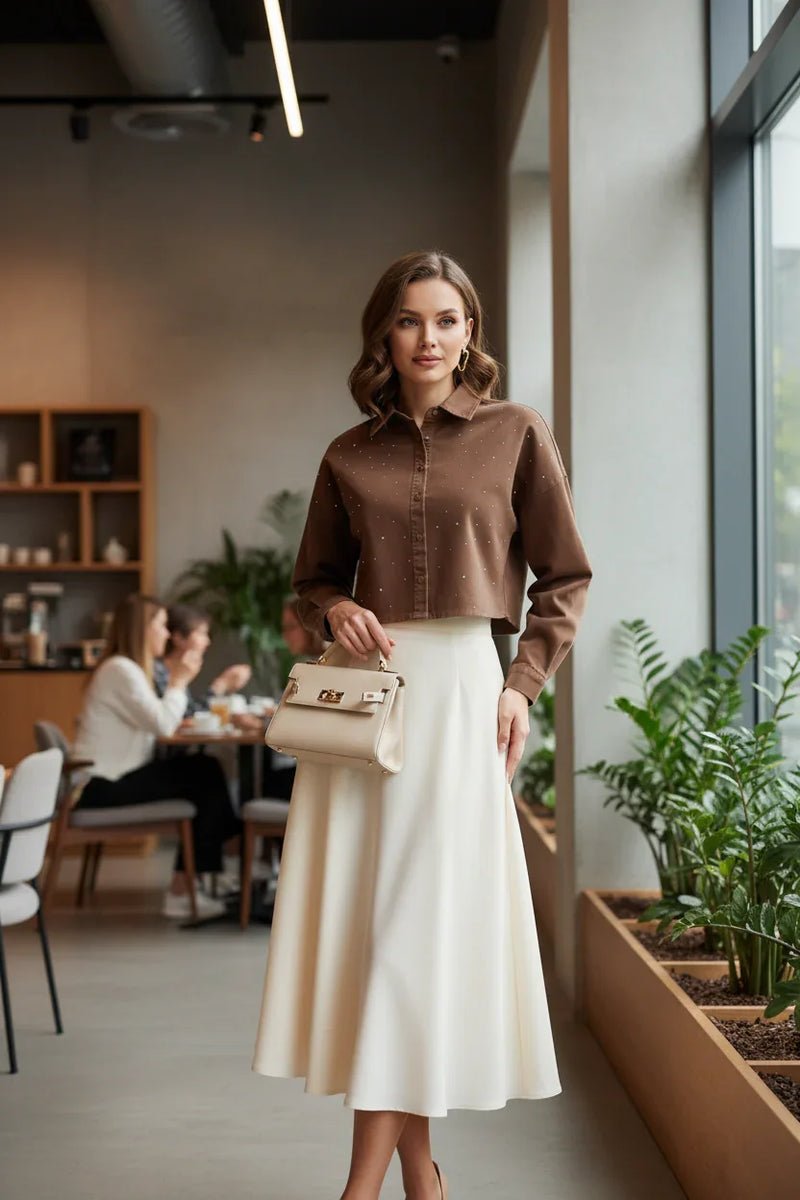 Woman in brown denim shirt with cream midi skirt
