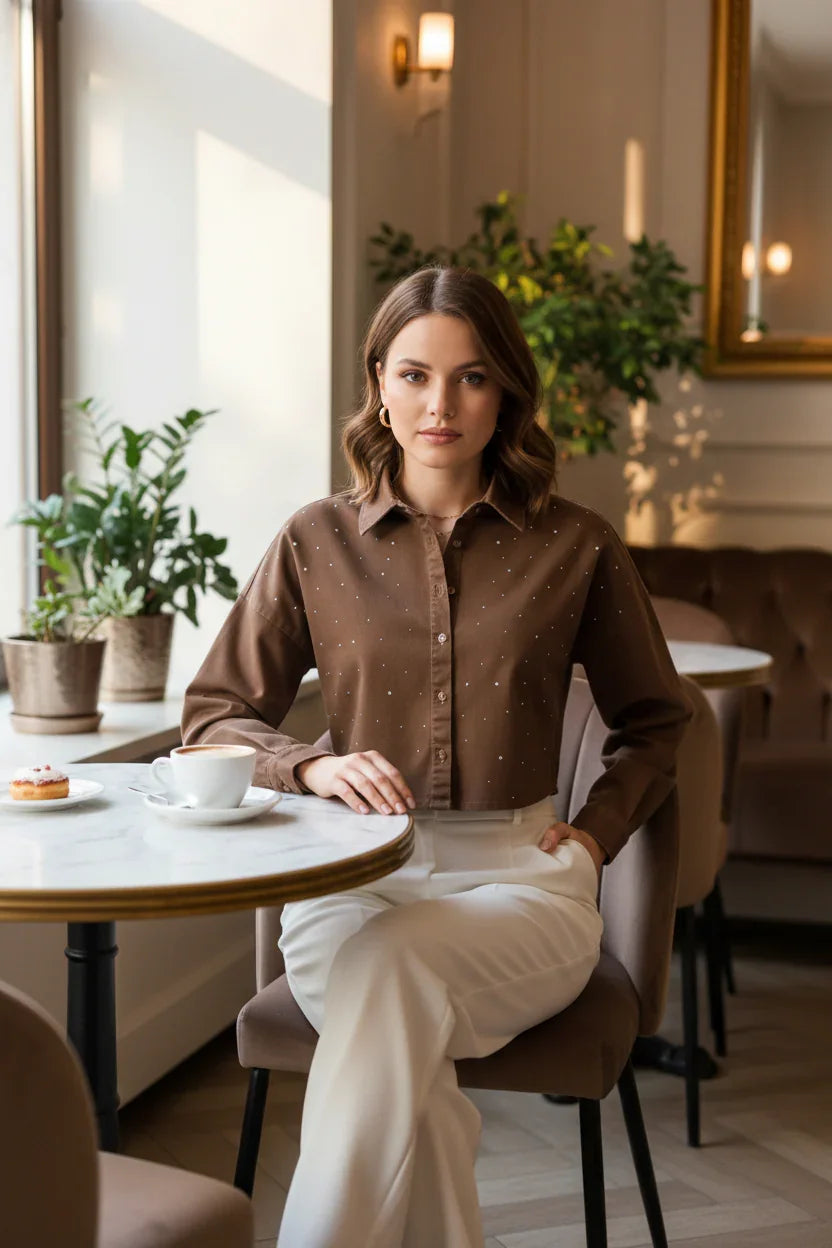 Woman in brown denim shirt with white pants, front view at café
