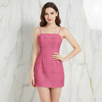Woman in pink floral mini dress with spaghetti straps posing against marble wall, Ivorynn fashion