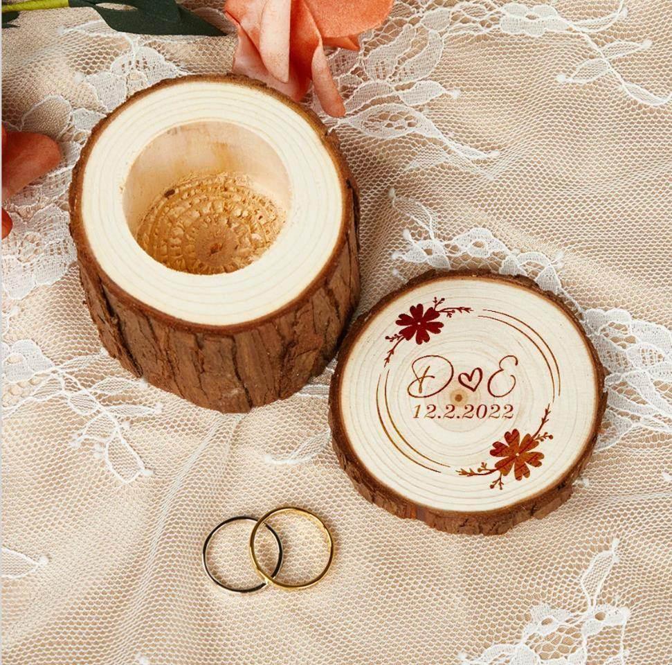 Personalized wooden ring box with engraved names, wedding date, and floral accents on lace, featuring two rings