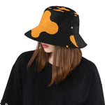 Woman in black shirt wearing ivorynn orange splatter print black bucket hat