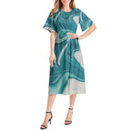 Woman modeling a teal and ivory marble print short sleeve midi dress, sold at Ivorynn